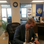 Signing transfer of title for Susitna, John Moosey, Borough Manager