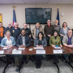 Legislators and Assembly: Front row, left to right, Rep. Colleen Sullivan-Leonard, Rep. DeLena Johnson, Sen. David Wilson, Rep. Cathy Tilton, Sen. Shelley Hughes, Sen. Mike Shower. Back row left to right: Borough Manager John Moosey near moose image. Assembly Member Jesse Sumner, Assembly Member Ted Leonard, Assembly Member Dan Mayfield, Mayor Vern Halter, Rep. George Rauscher, Deputy Mayor Matthew Beck, Assembly Member Jim Sykes, Assembly Member Tam Boeve, Assembly Member George McKee.